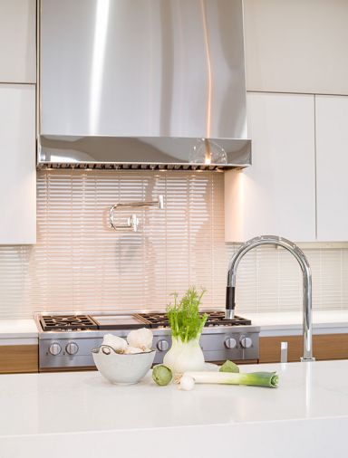 Eye-catching range 1x6 backsplash by Dal Tile Color Wave in Feather White.