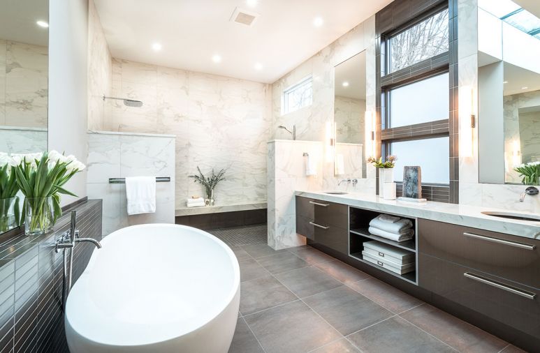 Dual sink vanity with quartzite countertops from Pental. Stacked windows framed in Metallic subway tile that echo fireplace surround in master bedroom. Tech Lighting sconces with brushed nickel cuff on mirrored wall.