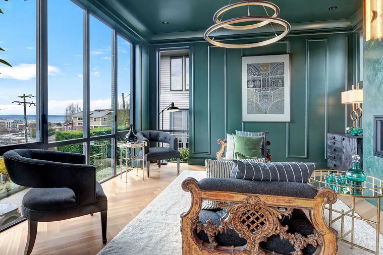 Double pocket doors off the adjacent kitchen open onto the formal sitting room portion of the setback carriage house with ultra-modern exterior. Benjamin Moore Essex Green highlights walls/ceiling and traditional molding collection. Venetian plaster fireplace finish. Rogers chose a contrasting contemporary circular LED chandelier by West Elm to reiterate Space Needle’s design.