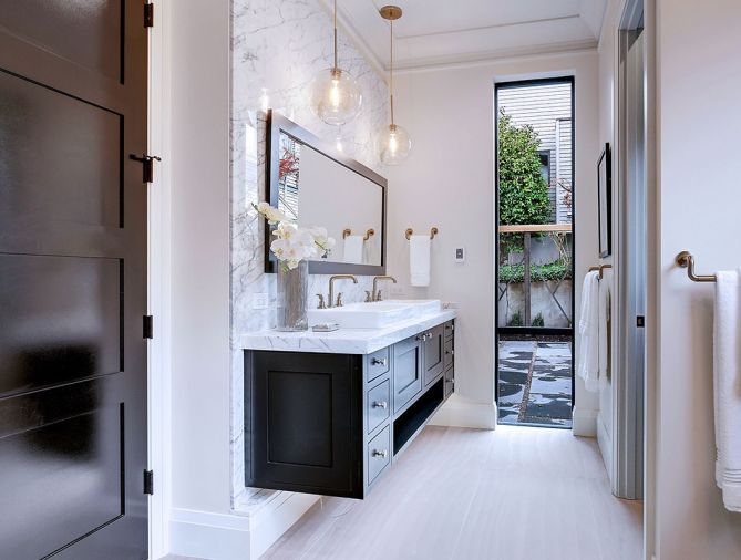 Floating dual vanity crowned by West Elm Sculptural Glass pendants echo three triple bulb pendants found over kitchen island. Fleetwood window to patio.