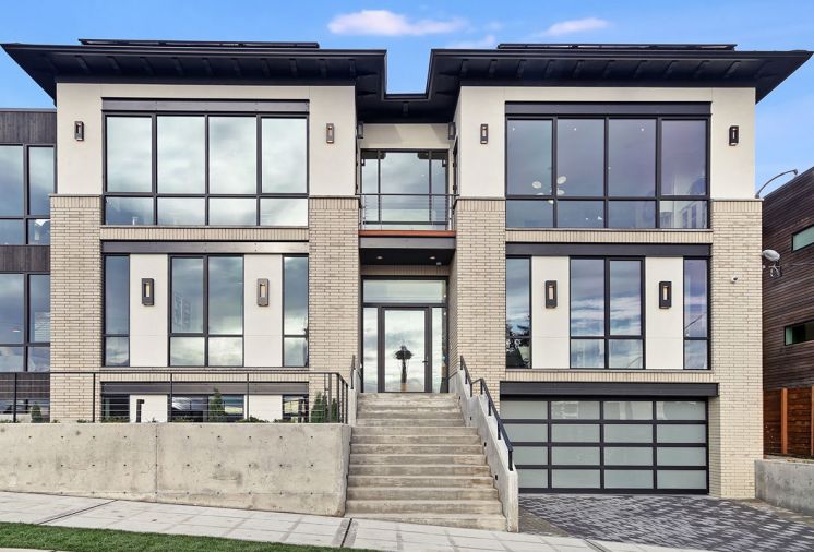 Aspen colored Norman size brick and real stucco add Georgian style to exterior. Steel lentils frame Fleetwood windows. Vertical black tongue-groove siding on carriage house.