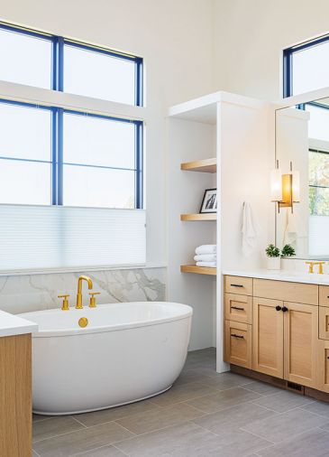 Master Bath Kohler tub with Purist Modern Gold finish tub filler and faucets; black Emtek hardware. Arteriors Haynes sconces. Modern Grey 12x24 porcelain Statements Tile flooring.