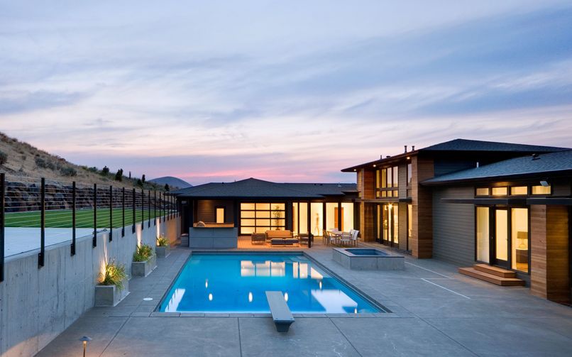 The pool, spa and cabana located on the south-facing side of the home include views of the Peak of Badger Mountain. At right, the master bedroom features direct access to the pool and sports court beyond.