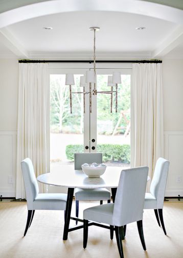 A high ceiling and French doors help fill the refreshed dining room with light.