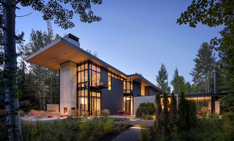 The steel-and-wood-clad Stirrup House features Fleetwood Kona Windows beneath a steel roof system that flexes beneath weighty snow. Glass-box master suite right occupies the secondary portion of “T” shape architecture. 
Photography ©Aaron Leitz