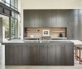 The entry foyer opens onto the open plan kitchen. Matte ebonized solid rift cut oak cabinetry countered by black granite and Caesarstone countertop. Square Guest Chair stools by BDDW.