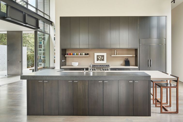 The entry foyer opens onto the open plan kitchen. Matte ebonized solid rift cut oak cabinetry countered by black granite and Caesarstone countertop. Square Guest Chair stools by BDDW.