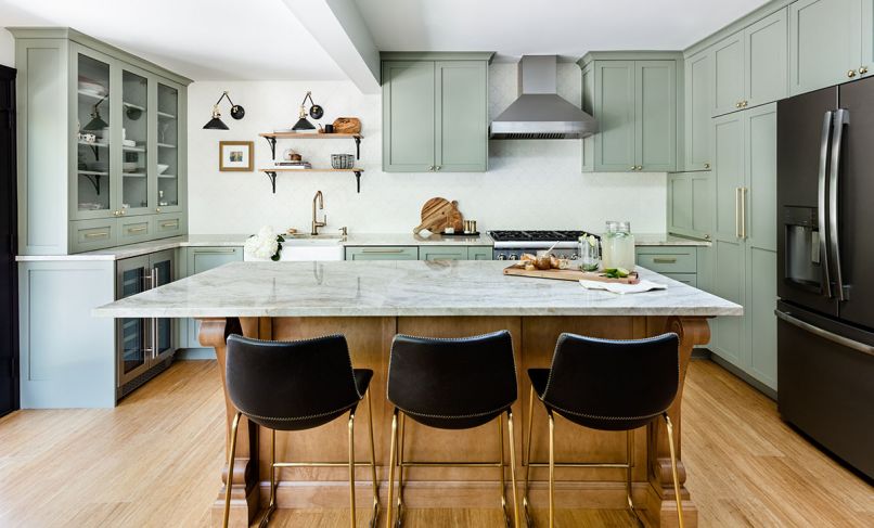 The Taj Mahal quartzite topped island is the focal point of the new kitchen while cabinets wrap around the walls before ending at a china hutch fitted with a beverage refrigerator. A beam is the only remnant of the wall that cut the kitchen in half. Designer Popov diminished the beam’s impact by dividing the wall into sink and range zones and steering the eye to shelving above the sink. Beside the refrigerator, the pantry was built around a venting pipe in a second accommodation of the home’s structural history.