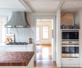 The homeowners requested that appliance spaces were maintained. A pass through to the left of the cooktop gives a glimpse of the rest of the home, while a cutout above the wall ovens provides light to a hallway.