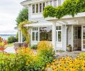 The home’s entrance, contrary to most lakeside homes, faces the water, embraced by a golden-hued garden.