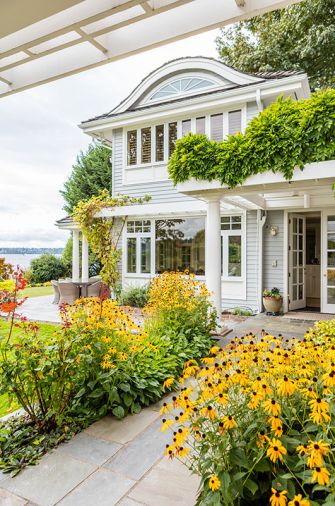 The home’s entrance, contrary to most lakeside homes, faces the water, embraced by a golden-hued garden.