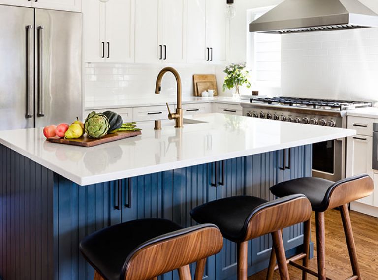 Venetian Stone Works installed the Pental quartz island countertop. The eye-catching island beadboard cabinetry features Sherman Williams Mount Etna paint for visual contrast. White subway tile backsplash wraps around a pair of Milgard Tuscany windows flanking the Fisher Peykel range. Article barstools are comfortable and easy-to-clean even with kids. Eakman Construction worked closely with Prince and Lindman to successfully deliver Beth’s vision. Delta Trinisic Champagne bronze fixtures. Black hardware echoes Craftsman style pendants by Restoration Hardware.