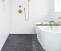 Black hex floor tiles add dramatic contrast to serene corner of master bath. Kohler Purist matte brass tub filler and fixtures echo kitchen sink hardware. Luxurious 70  Signature Hardware tub stands away from wall for easy cleaning.