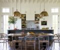 Vaulted ceilings add a sense of spaciousness to the kitchen/dining room when families gather for meals. Wire brushed wide plank oak flooring with custom finish by Natural Creations runs throughout home. Painted Benjamin Moore Gray Garden kitchen island by Traditional Woodcraft. Bosch electric cooktop with Clé Zellige backsplash tiles; freestanding custom stained oak shelving. Shiplap 1x6 walls by Windsor One. Custom hood and cabinetry: Traditional Woodcraft. Oversized Circa Lighting pendants. Custom dining table by Meyer Wells; Four Hands dining chairs.