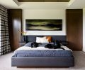 A custom headboard and bed designed to fit between the faux cabinet turned doorway at right and cabinet at left is large enough for the family’s beloved black labs as well.