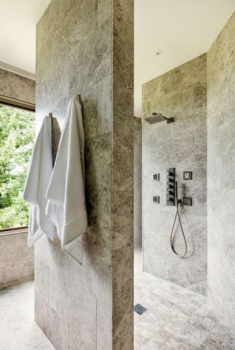 Silver Sands limestone shower and flooring with MGS showerhead create a spacious and seamless master bath with plenty of window light.