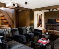 Existing central staircase was given a facelift by opening the wall up with glass, newly paneled wall and stair light. A Terry O’Neill print of Rachel Welch spices up the scene. Bar stools by Inform Interiors. Mayer Design coffee table.