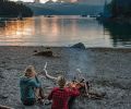 After a long, hard summer’s day of fishing in Alaska, Laukitis and Neaton relax on shore before a fire made of driftwood, where they feast upon the beauty of their world.