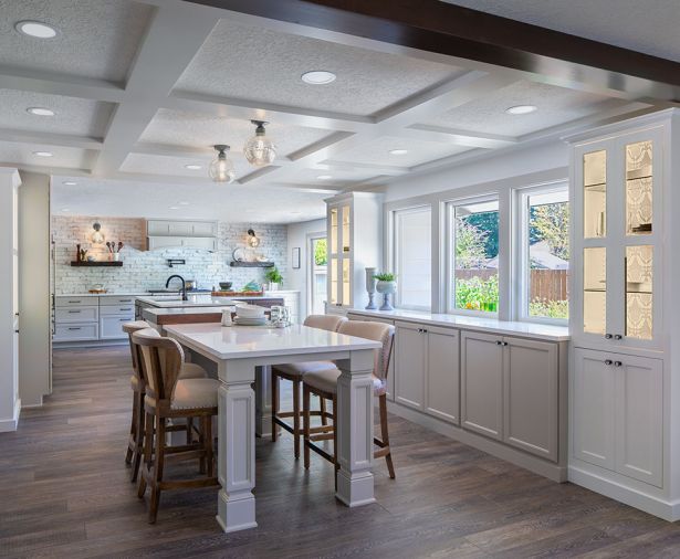 A rustic ceramic subway tile reaches from the countertop to the ceiling and echoes the tones used in both the revamped kitchen and casual eating area. Counters throughout are Cambria Torquay quartz. One window grew to a larger window and French doors to allow access to the large backyard and to let the light stream in. The couple, who are not fans of upper cabinets, limited their use to one corner, which provides a coffee station.