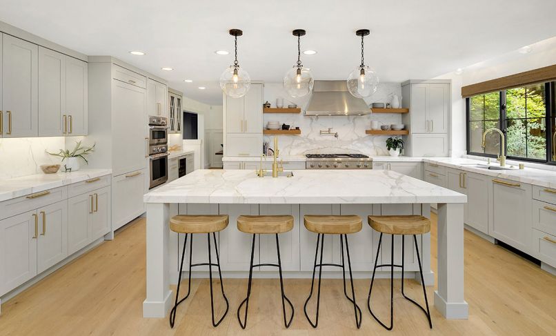 The mixed use of metals in the Thermador stovetop and hood, and brass pot-filler faucet and cabinet hardware work to add some sparkle to the room’s other surfaces. Open shelving provides convenient storage for plates, bowls and other dishes.