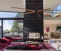 Elizabeth Stretch of Stretch Design chose vital colors to enliven the living space: burgundy rug; fuchsia furnishings pop against Shou Sugi Ban fireplace.