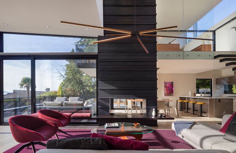Elizabeth Stretch of Stretch Design chose vital colors to enliven the living space: burgundy rug; fuchsia furnishings pop against Shou Sugi Ban fireplace.
