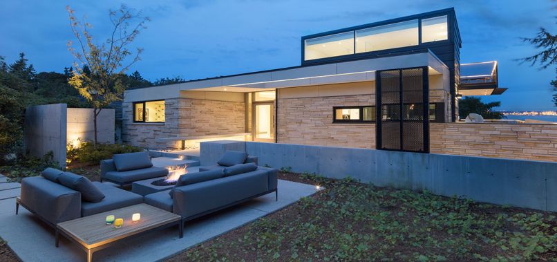 Dramatic entrance with Wilkinson sandstone. Black perforated metal screens obscure roof supports cleverly upheld by rare earth magnets. A Sunburst Honey Locust tree framed by concrete obscures neighboring driveway.