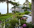 The bay is visible from the pathway of locally quarried alger granite steppingstones that lead past the sunken spa to the original reconstituted staircase to the beach. Lynne suggested salvaging the women’s pebble mosaics which Broadhurst fashioned into a pathway down the cliff face. Big Blue Sea Holly (Eryngium zabelii), foxglove, mullein, libertia, Johnson’s Blue geraniums and allium flourish alongside one another. The main terrace is at right. Broadhurst’s newly designed Sun Garden left.