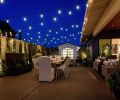 Covered outdoor dining area right faces garden area framed by triple-faucet fountain and horizontal cedar fencing for privacy. Outdoor furniture form KEY Home Furnishings.