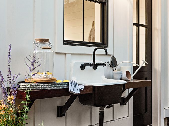 Rejuvenation outdoor sink flanked by madrone wood shelves alongside the she shed Dutch door.