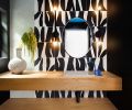 Adjoining the kitchen, the powder room generates talk with its blue ceiling, blue faucet and zebra-like black-and-white wall tile.