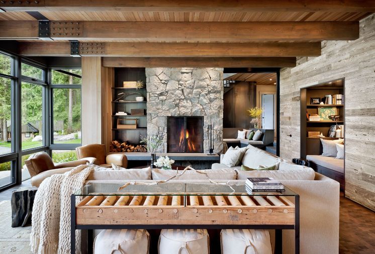 Old conveyor belt turned glass-topped console table by Cisco Home. Canvas ottomans with nautical rope detailing give nod to the sea. Restoration Hardware leather club chairs. Circular coffee table features inlaid metal constellation of the night the couple was married.