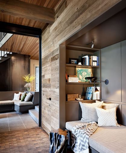 Darker walls (Sherwin Williams Urbane Bronze) reinforce coziness of reading nook with twin bed-size seating. Adjustable flush mount O’Lampia wall sconce. Custom metal pocket door closes off living area from mudroom. Pair of Restoration Hardware cast tables with bronze finish resemble tree trunk.