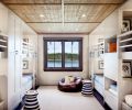 Artwork depicting animals wearing human clothing delights guests young and old. Ceiling hatches open to playroom in attic. Restoration Hardware leather bean bag chair; Serena & Lily rattan side table with nautical stripe.