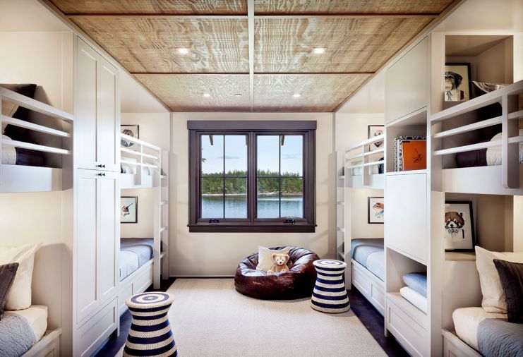 Artwork depicting animals wearing human clothing delights guests young and old. Ceiling hatches open to playroom in attic. Restoration Hardware leather bean bag chair; Serena & Lily rattan side table with nautical stripe.