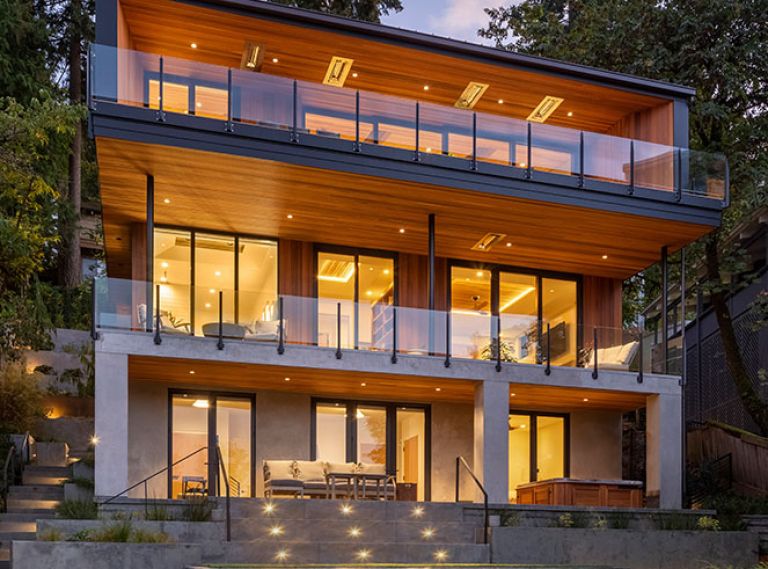 Architects teamed with Riverland Homes to replace an oft-remodeled 1930s home with modern Pacific Northwest design with unobstructed views of Oswego Lake. The team dug into steep hillside to accommodate stacked design. Truncated patio was replaced by a multi-layered landscape by Laura Canfield.