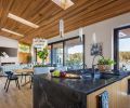 Kitchen island Vanilla Noir Polished Caesarstone. Kolbe windows from Portland Millwork and 30  Weiland lift and slide door opens onto view. Coulee Concrete stucco over plaster.