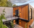 Complex steel bridge with concrete cap adds curb appeal, drawing eye to red cedar trimmed entry, Portland Millwork Kolbe door. Black stained vertical cedar frames Kolbe window.