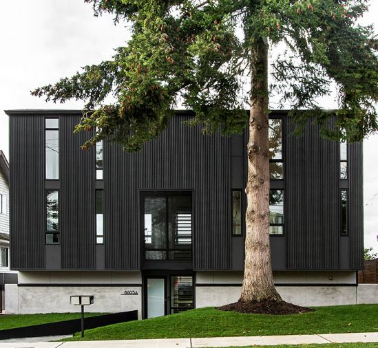 The home’s corrugated metal exterior creates its architectural splendor. Window above entry features perforated metal screen reiterating interior staircase design. Entry walkway adds unexpected diagonal angle to save existing tree’s roots. Evergreen tree provides year-round privacy.