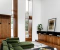 LDB Homes furred out wall to install a pair of deep-set Ply Gem windows trimmed in handsome walnut that rise over 20  to meet the stunning angled ceiling. Cozy reading nook at left is tucked within wall thickness.