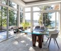 Moon captures forest and lake views from corner home office across wraparound terraces with custom steel railings, firepit, seating and staircase down to newly landscaped yard and reconfigured pool. Restoration Hardware 72  reclaimed V-form wood and glass dining table turned desk reminded homeowner of his alma mater “UW.” Ivory Hexa Hide rug and polished nickel Arc task floor lamp also by RH. Rug design repeats a “hive” theme found throughout the home. Soffit lighting when dimmed makes night-time view of lake sparkle.