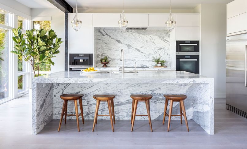 Blackened steel structural moment frame for seismic resilience draws eye to sleek, handleless SieMatic upper cabinetry. SieMatic’s streamlined profile perfectly frames the dramatic Calacatta Statuario honed marble backsplash from Meta Marble and Granite. Moon raises the Thermador exhaust hood to showcase it. Same marble island features waterfall bookends. Waterstone faucet paired with Julien sink. Trio of Tech Lighting pendants. A pair of Electrolux refrigerators/freezers are joined for larger storage opportunities. Lengo Bastone wide plank ROMA European Elegance, European White Oak flooring.