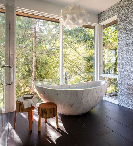 Nestled in the master bath between shower and double vanity is the custom carved 1200 lb. imported tub. Ann Sacks floor tile. EQLight Cloud Pendant.
