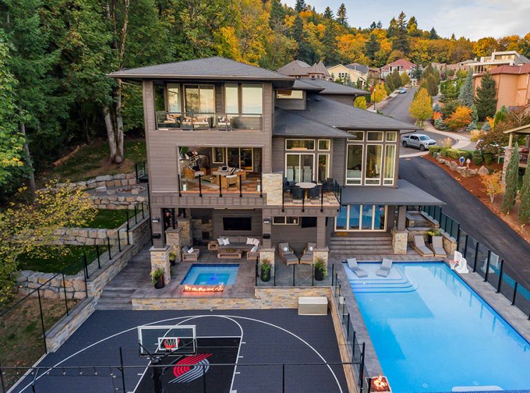 SPORT COURT The Sport Court, separated from pool by topless glass and topped glass railing installed by Rail Pro, was made possible by 13  South retaining wall that wraps around backyard area.