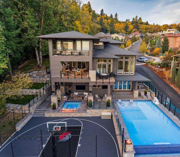 SPORT COURT The Sport Court, separated from pool by topless glass and topped glass railing installed by Rail Pro, was made possible by 13' South retaining wall that wraps around backyard area.