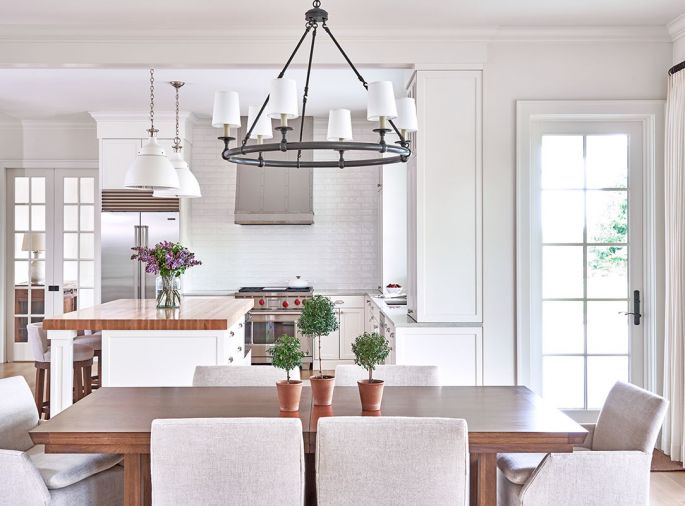 Light and bright, traditional Andersen windows from The Window & Door Shoppe diffuse the main level living and entertainment areas with natural light. Sub-Zero appliances from Judd & Black Appliance are complemented by a custom range hood. Lee Industry counter stools from J Garner Home in the Seattle Design Center (SDC) can tuck entirely under the kitchen island to facilitate entertaining.