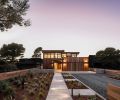 GSW Architects angled beach house to adhere to Bandon, Oregon, ordinance that determines tight setback along ocean so as not to obscure neighboring houses’ site lines. Garage at right with year-round succulent roof garden. Covered walkway to entry. Ipe tongue and groove siding with Lifetime Wood Treatment. Kolbe windows above. Marvin front door. Sense of traveling through landscape enhanced by low entry walls, easy-to-maintain coastal landscape, informal gravel driveway.