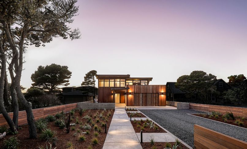 GSW Architects angled beach house to adhere to Bandon, Oregon, ordinance that determines tight setback along ocean so as not to obscure neighboring houses’ site lines. Garage at right with year-round succulent roof garden. Covered walkway to entry. Ipe tongue and groove siding with Lifetime Wood Treatment. Kolbe windows above. Marvin front door. Sense of traveling through landscape enhanced by low entry walls, easy-to-maintain coastal landscape, informal gravel driveway.