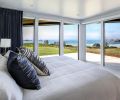 Each bedroom has its own personality; this guest bedroom features nautical navy draperies framing Princess Ewauna’s kittens left and Face Rock right.