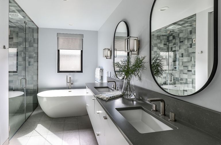 Primary bathroom features Z Collection Symphony (Grigio) tile and Dreamline cabinets with Alno hardware. Teltos quartz countertops in Beige Cloud read grey. Handsome Crosswater London tub.